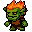 A green-skinned fire goblin with orange flames on its head and a brown tunic shuffles forward with sharp teeth and a flicking tongue.