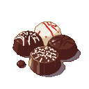 Assortment of chocolates: dark chocolates with white drizzles and a white truffle with red stripes.