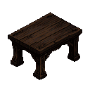 A heavy, dark oak medieval table with intricately carved legs and a rough, weathered wooden surface.